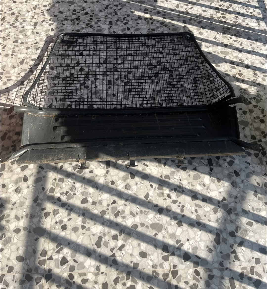 Black metal rack with mesh grille