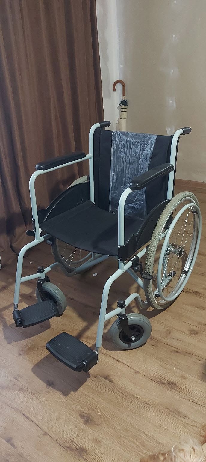Ayak dayamağı ve kol dayamağı olan tekerlekli sandalye