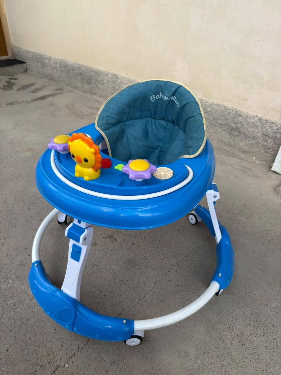 Mavi oyuncaklı bebek yürüteci
