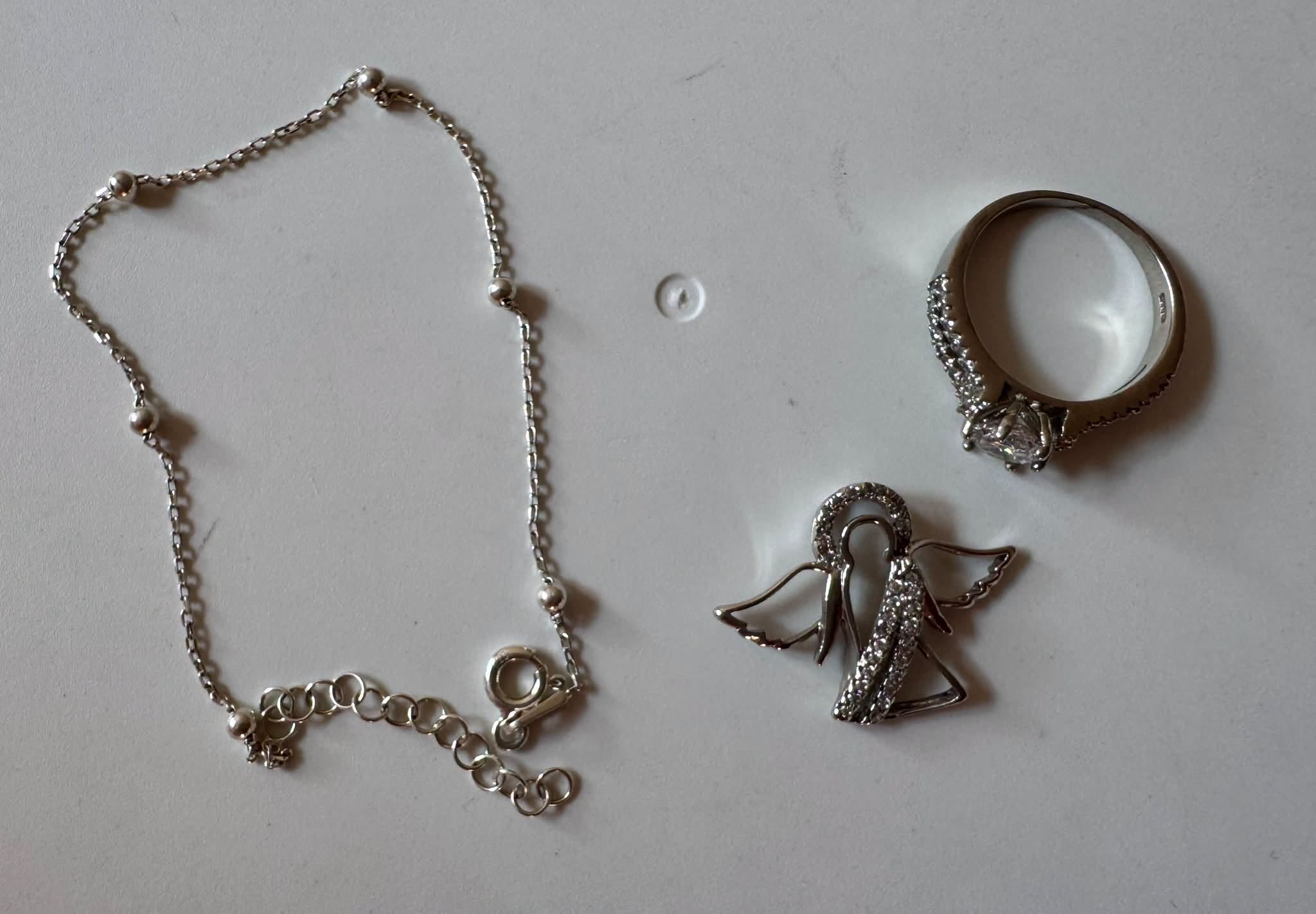 Silver ring, bracelet, and angel pendant